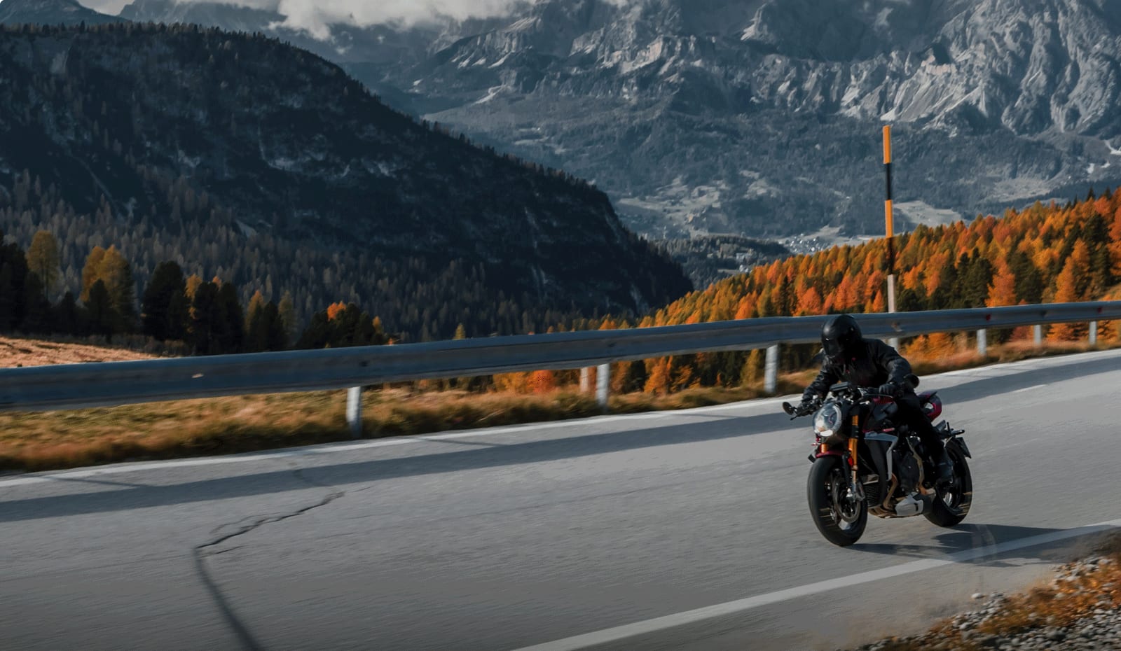 Motorcyclist riding through an alpine landscape